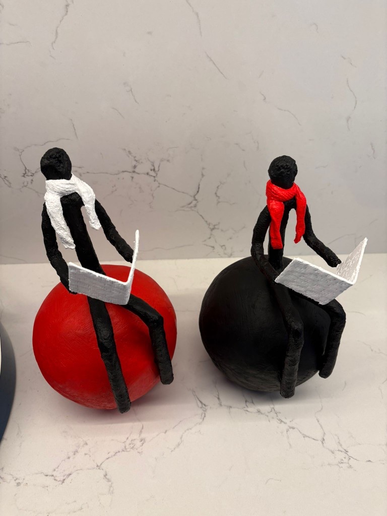 Grégoire Vanderstappen — pair of stylised figures reading on red and black spheres