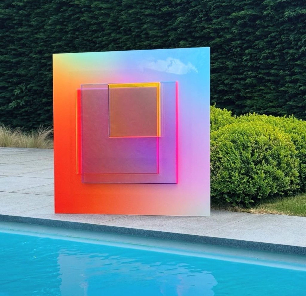 Joséphine geometric plexiglass sculpture with luminous colour gradients beside a swimming pool