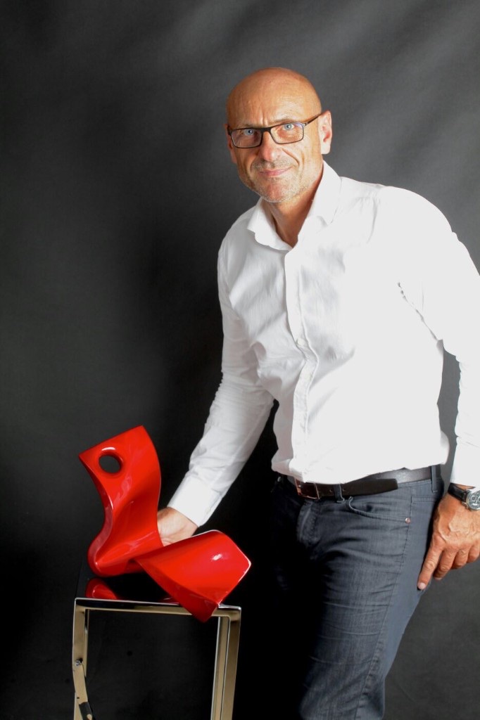 French sculptor Philippe Gauberti with a polished stainless steel sculptural work at Never Give Up Gallery